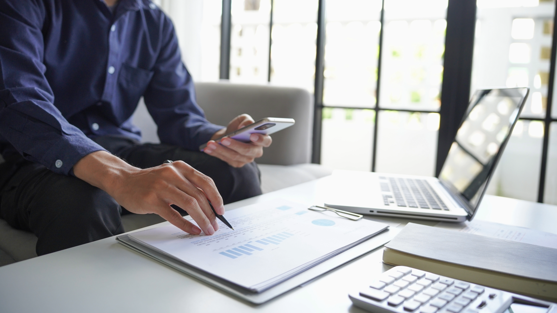 Business professional reviewing data on a desk, representing fair pay and living wage analysis.